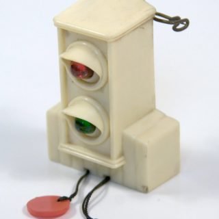Lighted pin. Pulling on string with colored plastic disc illuminates its respective light.