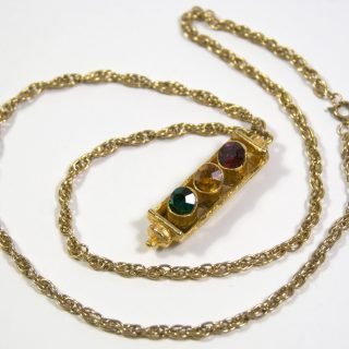 Gold tone single face traffic signal necklace with colored gem stone
