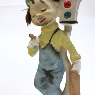Ceramic bum leaning against two-section traffic light