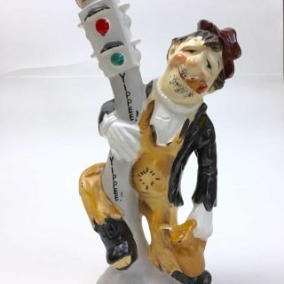 Ceramic decanter of bum haning on to traffic light, says "Yippee!"