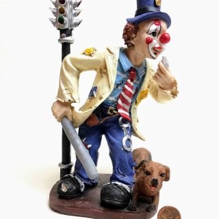 Figurine on a pedestal of a clown police officer and his dog next to a 4-way traffic light