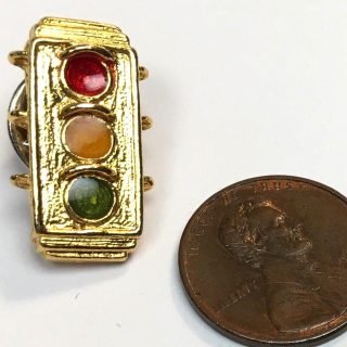 small traffic signal pin with red, yellow, and green indications