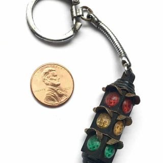 Black 4-way traffic light key chain likely from the 1960s or 70s.